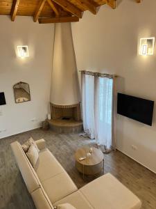 a living room with a couch and a fireplace at Stone House Bourgos in Koroni