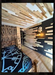 Un dormitorio con una cama y una pared de madera. en Le VALHALLA chambre freya, en Forges-les-Eaux
