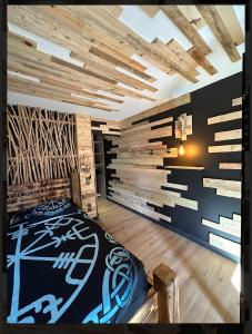 Un dormitorio con una cama y una pared de madera. en Le VALHALLA chambre freya, en Forges-les-Eaux