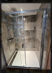 una ducha con puerta de cristal en un baño en Le VALHALLA chambre freya, en Forges-les-Eaux