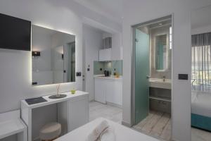 a white bathroom with a sink and a counter at Imagine Studios in Paliouri +52 photos