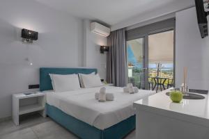 a hotel room with two beds and a balcony at Imagine Studios in Paliouri