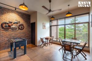 a living room with a table and a motorcycle on the wall at StayVista at Belmonte with Bonfire, Jacuzzi in Karjat