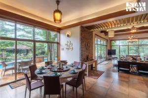 an open living room with a table and chairs at StayVista at Belmonte with Bonfire, Jacuzzi in Karjat