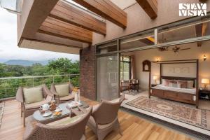 an open living room with a bed and a balcony at StayVista at Belmonte with Bonfire, Jacuzzi in Karjat +32 photos