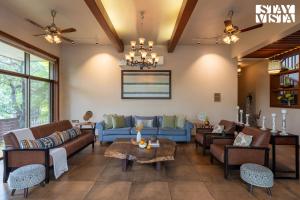 a living room with couches and tables at StayVista at Belmonte with Bonfire, Jacuzzi in Karjat