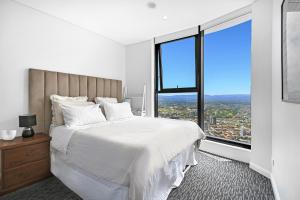 a bedroom with a white bed and a large window at Sky-High Villa with Wide Ocean Views - Pet Friendly in Gold Coast +17 photos