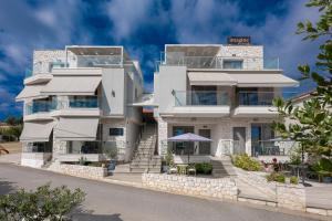 a large white house with a stone facade at Imagine Studios in Paliouri