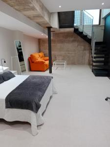 サラマンカにあるApartamentos Living Librerosのベッドルーム1室(ベッド1台、オレンジ色のソファ付)