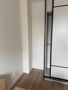 a room with a mirror and a white wall at Apartament Kaszmir in Kętrzyn