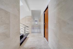 a hallway with a wooden door and marble walls at FabHotel Kayal Plaza in Coimbatore +25 photos