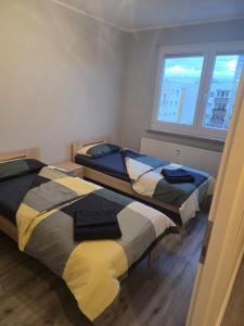 two beds in a small room with a window at Komfortable 2-Zimmer-Monteurwohnung für 4 Personen in Leipzig in Leipzig