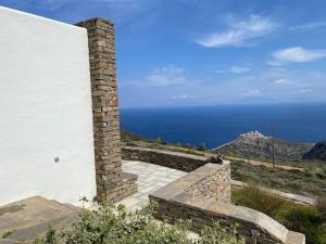 a brick chimney on the side of a building with the ocean at Bioclimatic stone built villa in Kastrianí