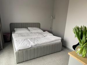 a bed with white sheets and pillows in a bedroom at Jasna Góra Apartament in Częstochowa +1 photo