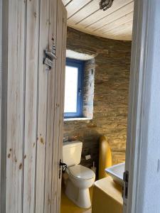 a bathroom with a white toilet and a window at Bioclimatic stone built villa in Kastrianí +47 photos