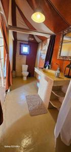 a bathroom with a sink and a toilet and water at Panoramic Desert Camp with jeep pickup included in Merzouga