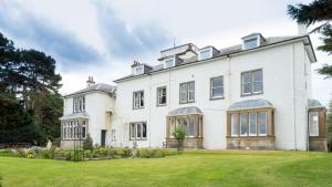 a large white house with a large yard at The Penthouse Self Catering in Nairn