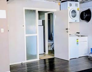 a room with a door and a washer and dryer at Park View 'Home Away From Home' in Feilding