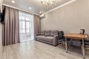a living room with a couch and a table at Expo Elite Apartments in Astana