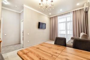 a dining room with a wooden table and chairs at Expo Elite Apartments in Astana +12 photos