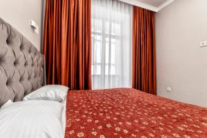 a bedroom with a bed and a large window at Expo Elite Apartments in Astana