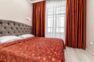 a bedroom with a bed and a large window at Expo Elite Apartments in Astana