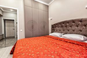a bedroom with a large bed with a red rug at Expo Elite Apartments in Astana