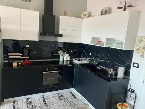 a black and white kitchen with white cabinets at Adriatic View Penthouse in Durrës
