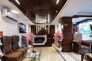 a lobby with a waiting room with chairs and a fireplace at HR Grand Hotel in New Delhi