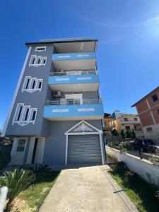 a tall blue building with a garage in front of it at Adriatic View Penthouse in Durrës