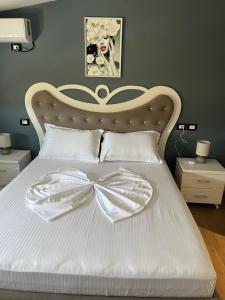 a bedroom with a white bed with a bow on it at Adriatic View Penthouse in Durrës