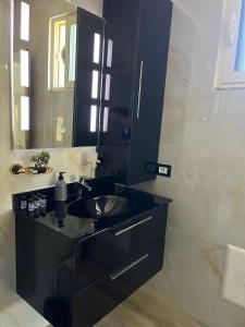 a bathroom with a black sink and a mirror at Adriatic View Penthouse in Durrës