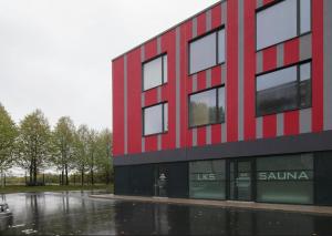 a red and black building in the rain at LKS apartments 2 in Koze