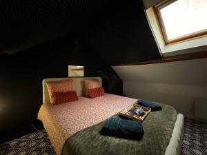 een kleine slaapkamer met een bed en een raam bij Secret Room Elegance, mystère et intimité in Souppes-sur-Loing
