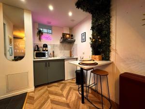 een keuken met een aanrecht en een tafel met krukken bij Secret Room Elegance, mystère et intimité in Souppes-sur-Loing