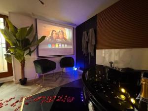 een kamer met een tv en een tafel en stoelen bij Secret Room Elegance, mystère et intimité in Souppes-sur-Loing +4 foto's