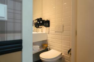 a bathroom with a toilet and a camera on the wall at Max Brown Hotel Canal District, part of Sircle Collection in Amsterdam +24 photos