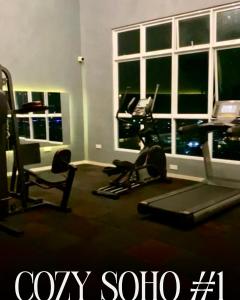 a room with a gym with a computer and a desk at Cozy Soho #1 The Stirling Suites by TwoKeys in Miri