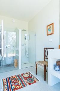 a white bathroom with a shower and a tub at Quinta Fonte Grande in Santiago do Cacém