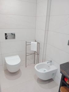 a white bathroom with a toilet and a sink at Aptos Living Libreros climatizados in Salamanca +48 photos