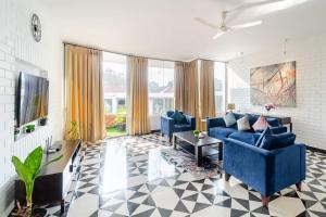a living room with two blue chairs and a tv at Coastal Grandeur by Da Alohas, Candolim in Nerul +42 photos