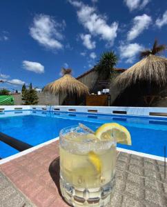 a drink on a table next to a swimming pool at Casa quinta en Pilar solo Eventos y Pasar el Día in Pilar