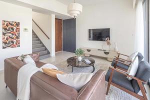 uma sala de estar com um sofá e uma mesa em Frank Porter - Nara, The Valley em ‘Ūd al Bayḑāʼ