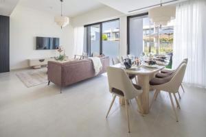 uma sala de estar com uma mesa de jantar e um sofá em Frank Porter - Nara, The Valley em ‘Ūd al Bayḑāʼ