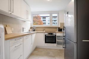 a kitchen with white cabinets and a stainless steel refrigerator at Geschäftsreisetraum mit 6 Betten in Heidenheim