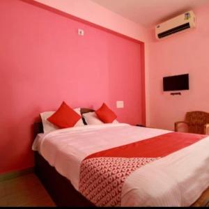 a bedroom with a large bed with red walls at Hotel Kalyani International in Mūlki