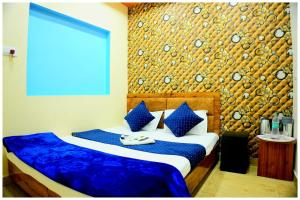 Un dormitorio con una cama con almohadas azules y blancas. en Hotel Ganaraj Sharnam -Near Mahakaleshwar Jyotirlinga #Air Conditioning Room #Free WiFi #Parking - Room Service #Best Hotel In Ujjain, en Ujjain 17 fotos más