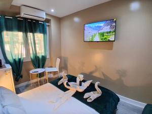 a bedroom with two dolls on a bed with a television at AS ROOMS Alicante in Alicante
