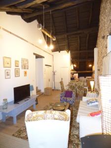 a living room with white chairs and a tv at Casa Luna de La Viliella in La Viliella