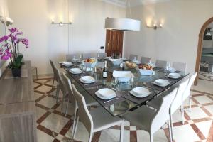 a dining room with a long glass table and chairs at Villa Sunset View Tenerife, Simply Amazing in Adeje